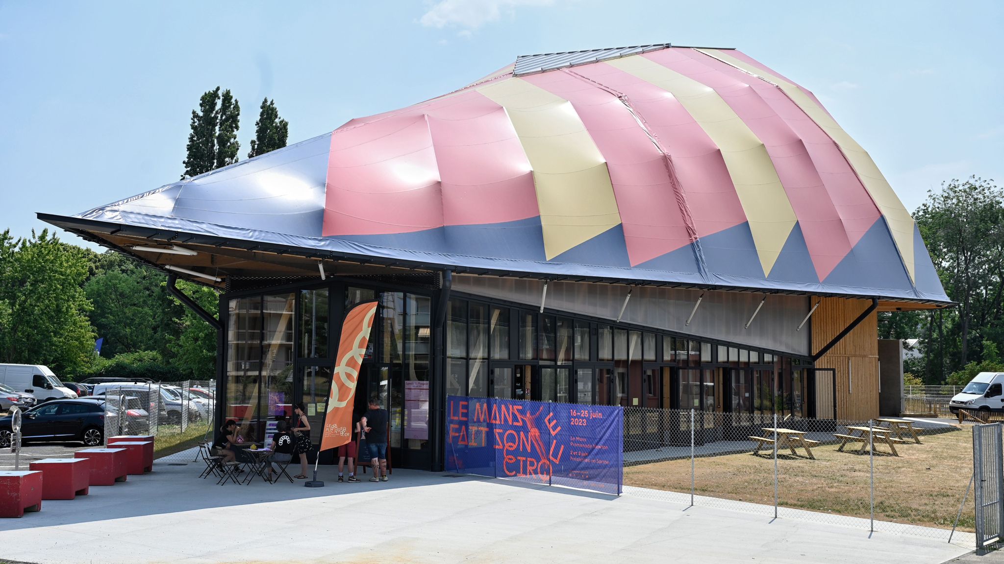 La Cité du Cirque, Le Plongeoir's building in Le Mans, with its pink, yellow and grey striped roof and a Le Mans fait son Cirque banner out front.