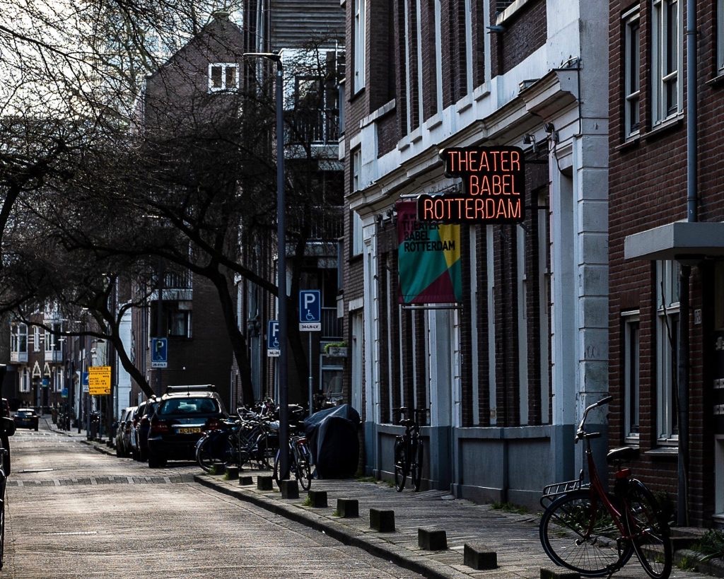 Theater Babel Rotterdam's neon sign above its entrance on a quiet street in Rotterdam
