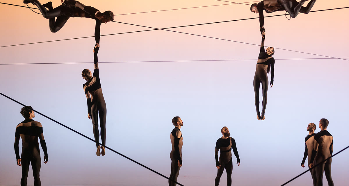 In Outsider, performers hang from lines strung across the stage, holding dancers in the air above the company